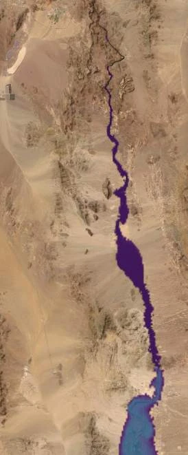 Black Canyon from above: a thin dark thread of water follows the channel floor, with one small pool widening mid-canyon