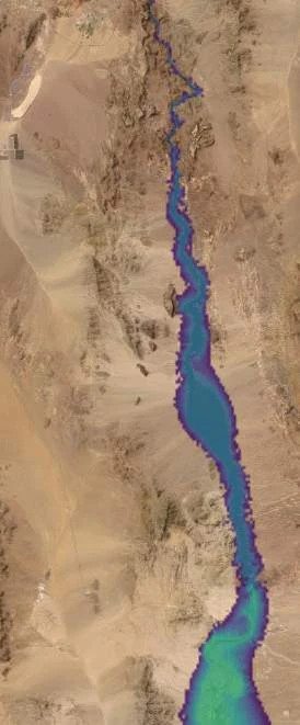 The highest stage shown: water fills the gorge broadly, with the depth ramp climbing through blue into green at the widest reaches